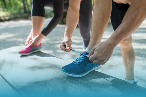 A Couple Tying Their Shoelaces On Exercise Shoes.