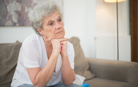 Elderly Woman Sitting On Sofa