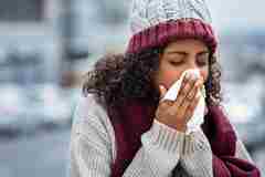 Woman With Cold Sneezing Outdoor