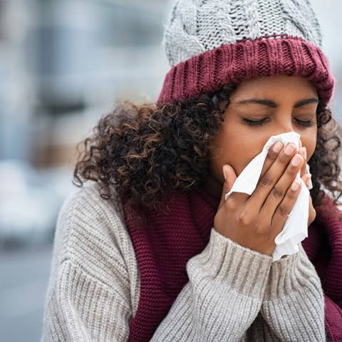 Woman With Cold Sneezing Outdoor