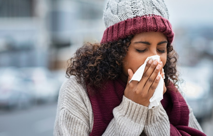 Woman With Cold Sneezing Outdoor
