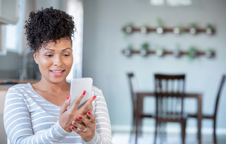 Woman Uses Smart Phone For Virtual Doctor's Appointment From Home