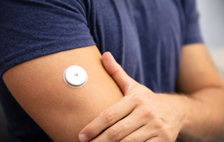 Man Testing Glucose Level With A Continuous Glucose Monitor