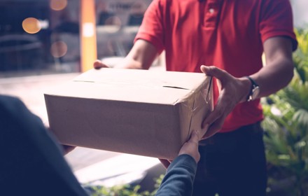 Delivery Person Handing Out Parcel To Customer
