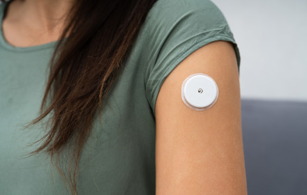 Woman Testing Glucose Level With A Continuous Glucose Monitor