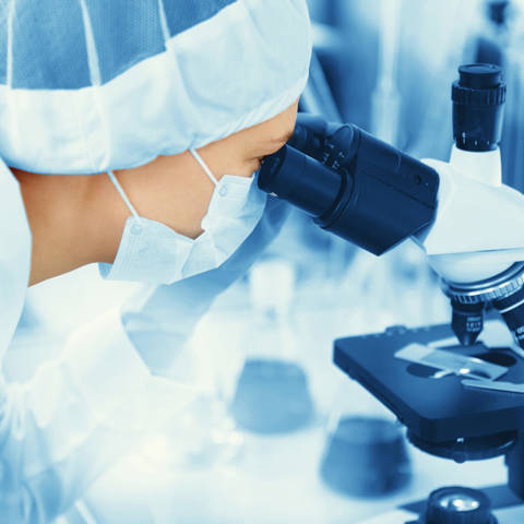 Researcher Looking Through Microscope