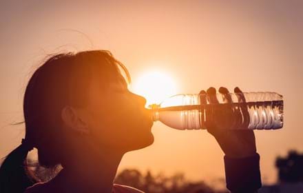 Woman Drinking Water In Hot Weather