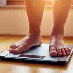 Person Weighing Themselves On Scales