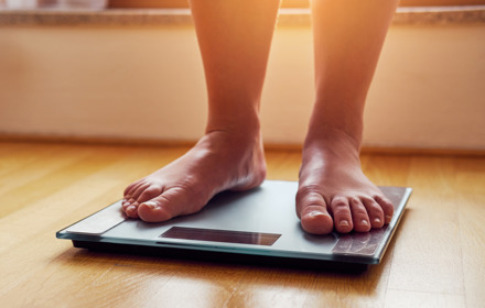 Person Weighing Themselves On Scales