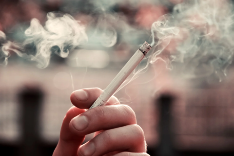 A Person Holding A Cigarette