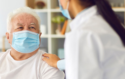 Elderly Patient And Healthcare Professional Wearing Masks